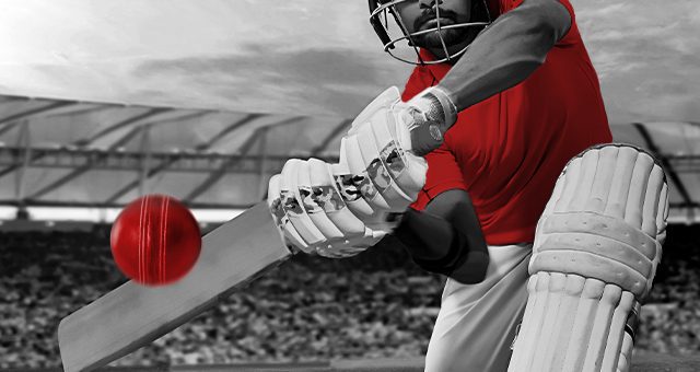 a batsman with a red shirt hitting a red cricket ball