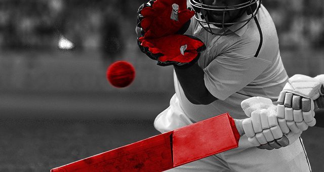 batsman with red bat trying to hit a red cricket ball and wicketkeeper with red gloves trying to catch the ball
