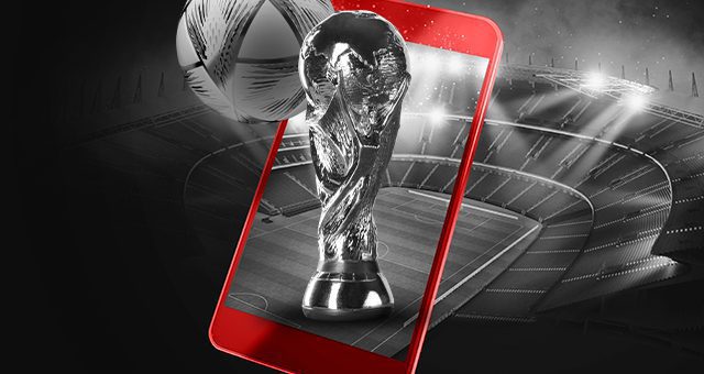 der Weltmeisterschaftspokal und der Weltmeisterschaftsball, die aus einem roten Smartphone hervorgehen