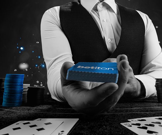 a live casino dealer offering a deck of betiton cards to the player