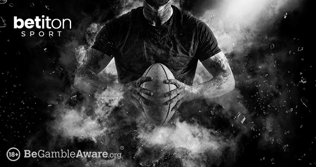 a rugby player holding a rugby ball in his hands