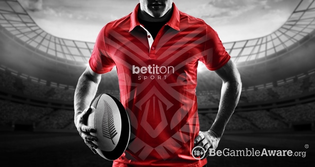 a rugby player with the betiton sport and all blacks logo on his jersey and ball
