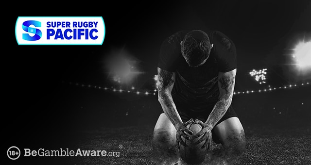 a player with tattoos holding down a rugby ball